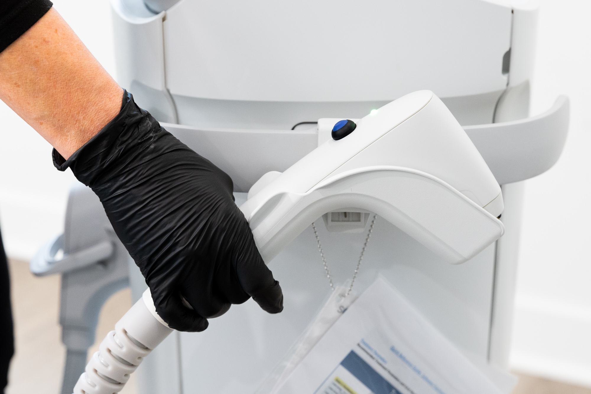 A person is holding the handpiece for a treatment called Sofwave