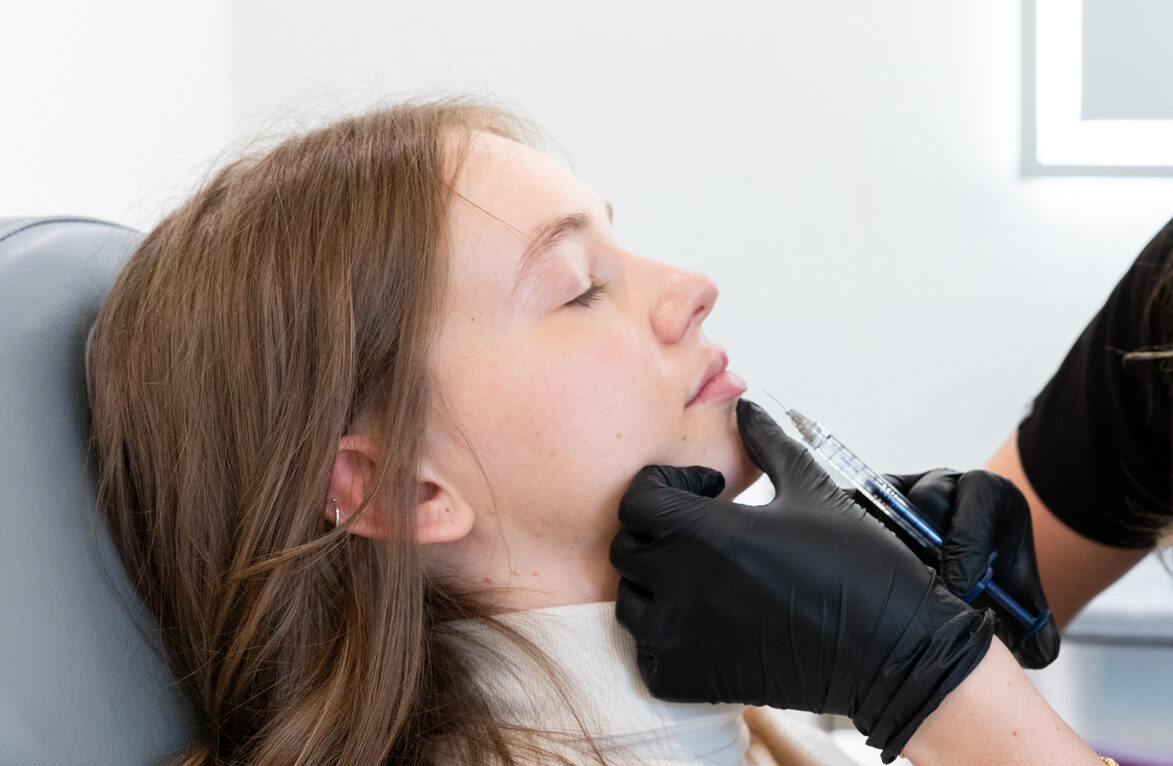 Close up of a young woman receiving a lip filler injection